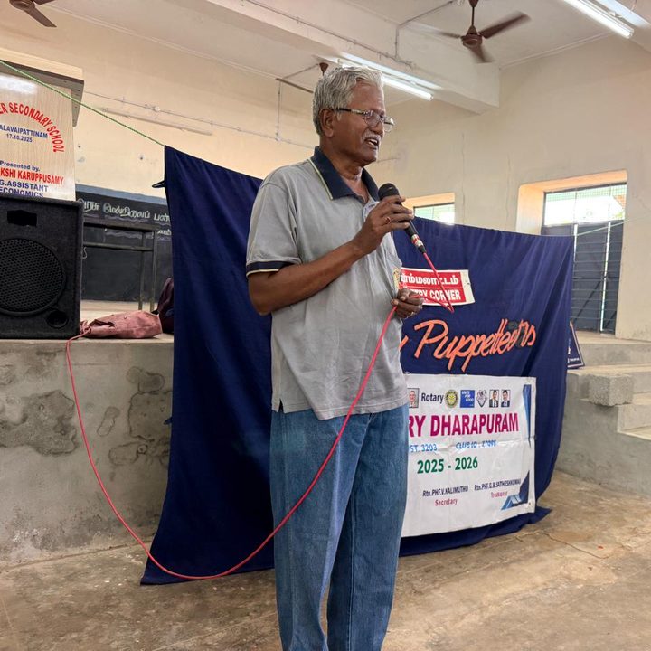 Dr. Dhanaraj addressing students in front of the Rainbow Puppetry stage